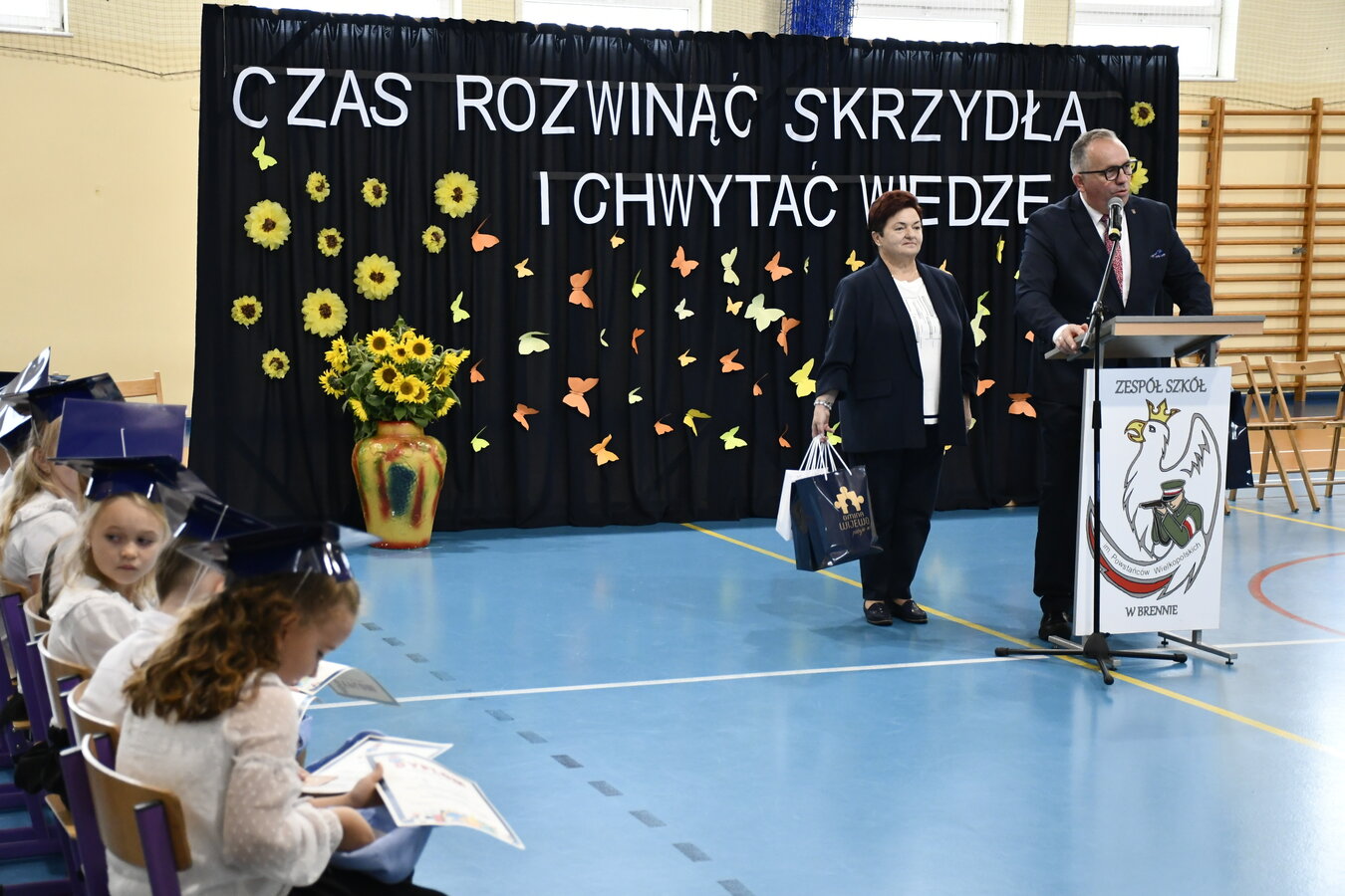 Zdjęcie przedstawia Wójta wraz z Przewodniczącą Rady  składającego życzenia pierwszoklasistom. 