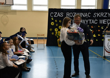 Zdjęcie przedstawia wręczenie upominków wychowawczyni klas pierwszych